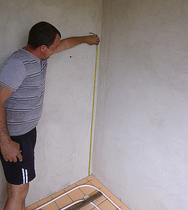 На фото – с помощью рулетки определяем разность уровней в помещении