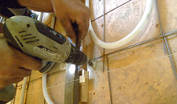 На фото – закрепляем маяки для будущей стяжки пола